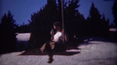 1946: Solo chairlift ride moving up spring conditions snowy mountain. MT HOOD,