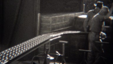 1946: Boxes moving conveyor belt at industrial packing facility.