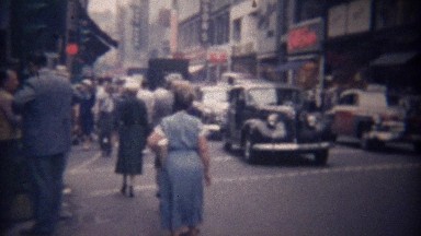 1948: Visitors stunned by fast busy downtown city street dwellers.