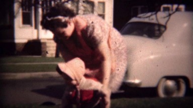 1948: Mother Supervises Pink Hooded Girl Playing on Sidewalk