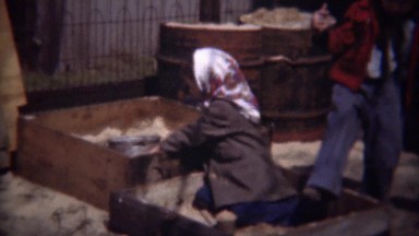 1948: Poor immigrant girl kids playing in industrial sandbox.