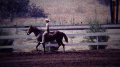 1967: Female horse rider in white costume practicing control.