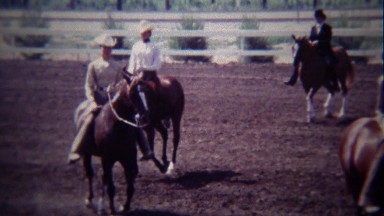 1967: Equestrian competition horse riders circling dirt track.
