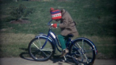 1962: Kids riding new oversized adult sized training wheel bikes.