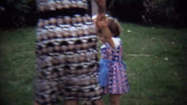 1973: Extended family circling play jumping fun with toddler child.