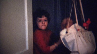 1973: Newborn baby bouncing on rubber band door mounted device.