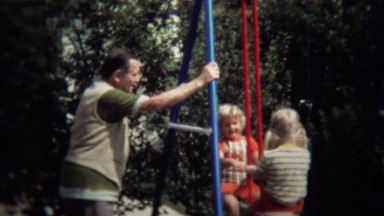 1971: Grandpa Supervising Kids Playing on Backyard Swingset and Seesaw