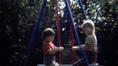 1971: Blonde Caucasian Kids Playing on Swing and Seesaw in Zagreb Backyard