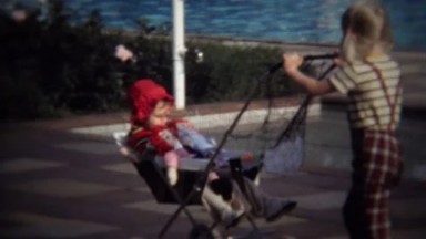 1971: Kid Sister Pushing Baby Stroller with Raggedy Anne and Andy Dolls