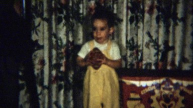 1959: Toddler kicks toy football indoors loves practicing.