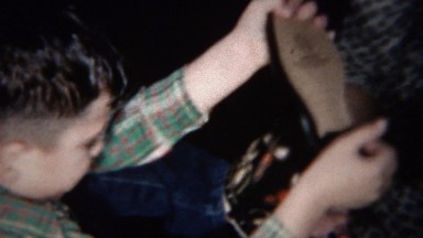 1959: Boy takes off socks and shoes and mom puts back on.