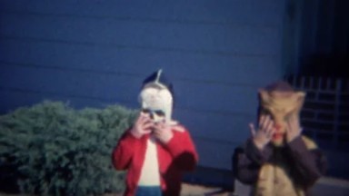 1961: Kids wear Halloween costume masks trick or treat time.