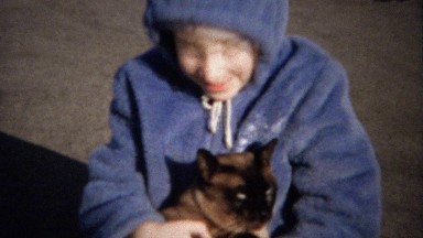 1963: Purple hoodie girl hugs cat kisses loves pet so very much.