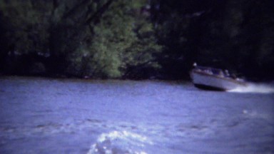 1962: Family waves in speed boat going up Mississippi river.