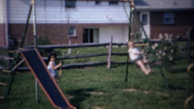 1963: Boy swings dangerously high on see saw type playground.
