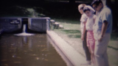 1961: Family Marveling at Gold Koi Fish in Pond at Botanical Garden