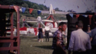 1961: Carnival fair amusement ride park crowds enjoying summer.
