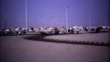 1974: Highway Traffic Tour Bus Driving Barren Desert Landscape
