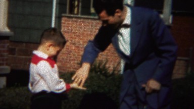 1964: Uncle teaching young boy rock paper scissors game.