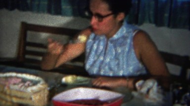 1964: Women eating cake piece ashamed looks away.