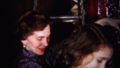 1964: Women hanging silver tisell decoration on Christmas tree.