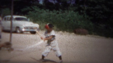 1964: Boy little league baseball strikeout swings at pitches in dirt.