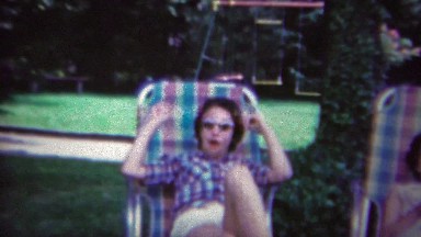 1965: Lounging family outdoor reunion event colorful lawn chairs.