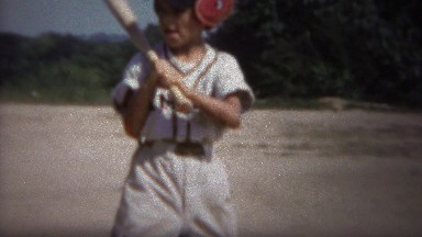 1964: Little league baseball batter hit by wild pitch jumps back.