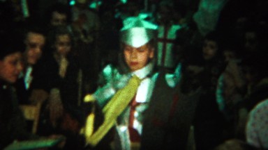 1964: Boy wearing knight costume crowd watching walk down aisle.