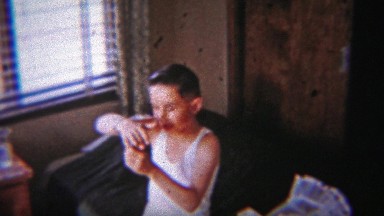 1954: Boy Mastering Padlock Device Seated on Bedroom Bed.