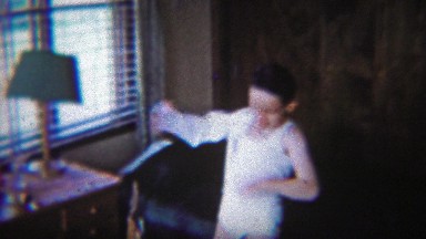1954: Dapper Young Lad Puts On White Dress Shirt In Modest Bedroom