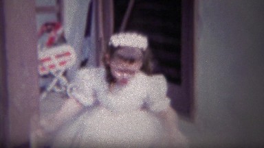 1954: Girl Looking for Easter Eggs in White Fancy Dress