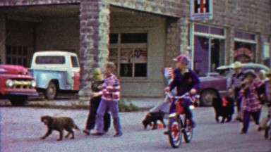 1959: Kids USA 4th of July parade marching downtown mainstreet.