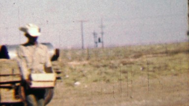 1958: Mexican Immigrant Man Carries Box with Daughter Walking Along