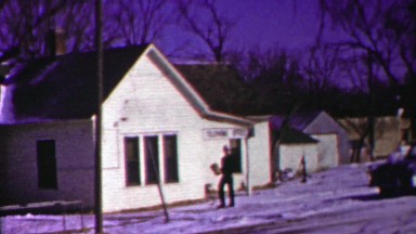 1958: Navy delivery man brings package from telephone office winter snow.