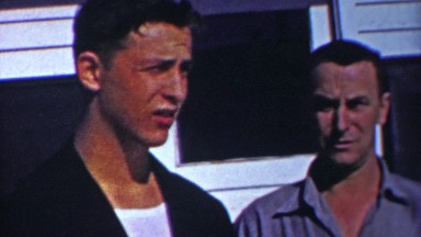 1958: Dark complexion handsome father son smoking cigars together.