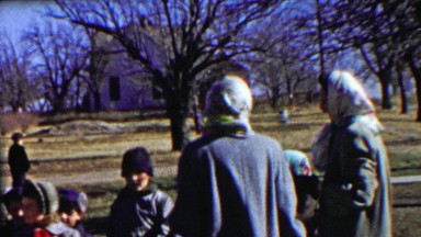 1958: Country schoolyard kids gather playground rural lifestyle.