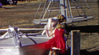 1958: Sister play on steel sturdy merry go round carousel park.