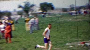 1958: Man leading high school track foot race long distance run.