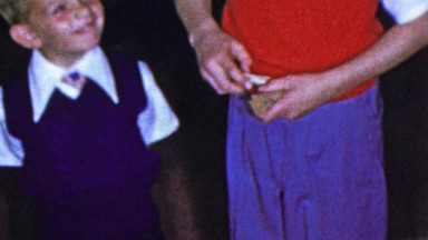 1963: Brother teaching kid how to play drop closepin in bottle game.