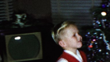 1963: Young caucasian boy carry olive on spoon Christmas tree game.