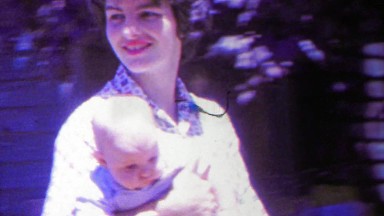 1963: Jackie ONassis look alike style mother carries baby.