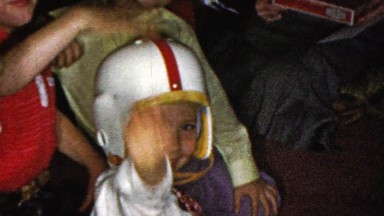 1964: Grade school kid football helmet wave classmates party.