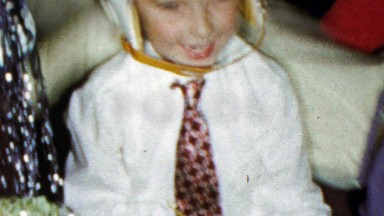 1964: Christmas gift unwrapping wearing football helmet necktie.