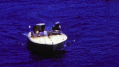 1962: Motor boat docking blue waters man suitcases boarding.