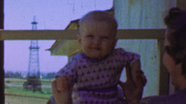 1957: Mother Raises Baby Near Oil Drilling Derrick in Backyard.