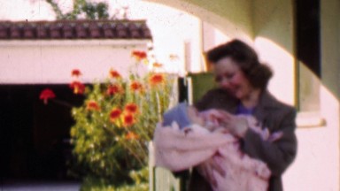1957: Loving mother holds precious bundled newborn baby.