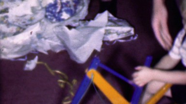 1957: Boy playing Christmas wrapping paper crane digging toy.