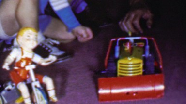 1957: Boy plays toy tractor farm plow tricycle pretty doll.
