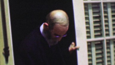 1958: Abraham Lincoln look alike man exits dark room into sunshine.